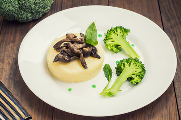 Mashed potatoes with mushrooms and boiled broccoli  sauce. Wooden background. Top view. Close-up