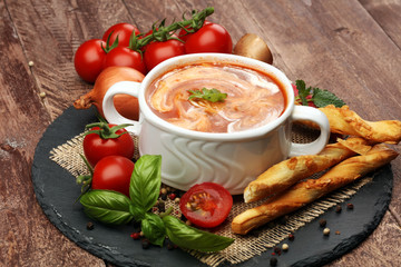 Tomato, red pepper soup, sauce with olive oil, rosemary and smoked paprika on a wooden background. 