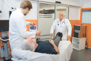 Obraz premium patient laying on bed and doctors checking on him