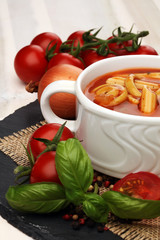 Tomato, red pepper soup, sauce with olive oil, rosemary and smoked paprika on a wooden background. 