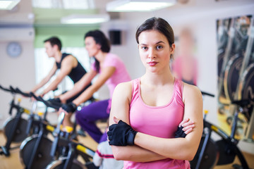 Fototapeta na wymiar Group training people biking in the gym, exercising legs doing cardio workout cycling bikes
