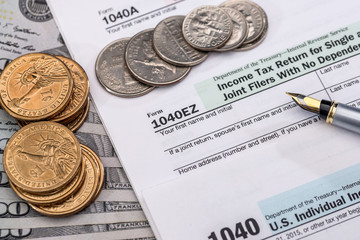 1040 US tax form with dolllr bills and coins. taxation concept.