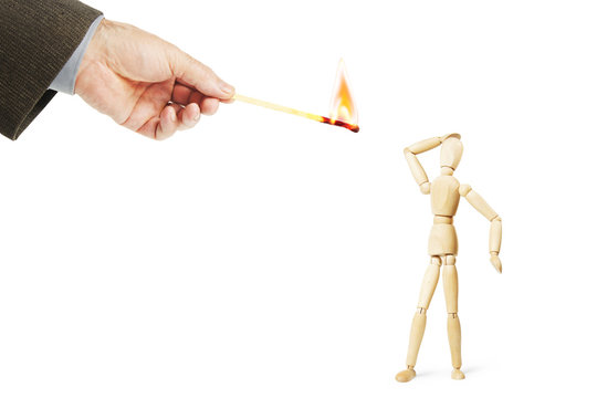 Man is afraid of burning fire. Abstract image with a wooden puppet