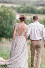 Couple in wedding attire with a bouquet of flowers and greenery