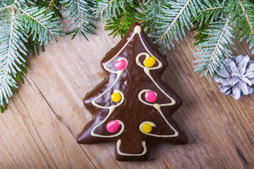 Gingerbread cookie in the shape of Christmas trees on wooden background, copy space