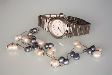 женские наручные часы и ожерелье из жемчуга
