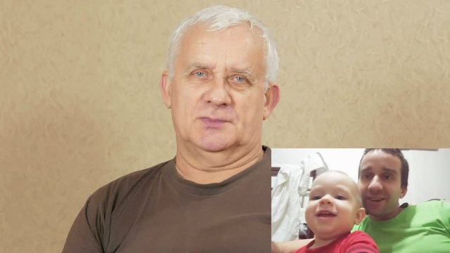 Man aged communicates with the son and grandson on the internet. PIP: see the whole family on the screen. Dad and son hugging and kissing in the frame