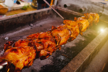 Free range chicken for roasting traditional at street food vendor market , thai local food. Selective focus and  with lighting flare effect.