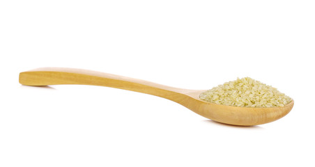 white sesame seeds in spoon on white background