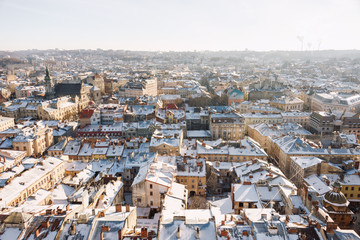 Naklejka premium Winter panorama view from the Town Hall on the downtown in Lviv, Ukraine. Old buildings. Roofs covered with snow.