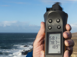 Hand holding up a anemometer and measuring the wind speed in kil