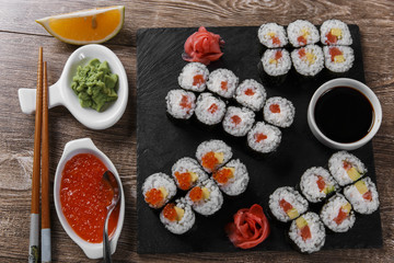 sushi rolls and ingredients served on a wooden surface