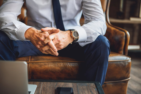 Man in suit interlacing fingers