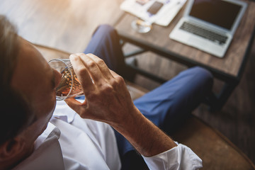 Mature man making slip of beverage