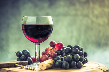 red wine glass and fresh grapes and cork
