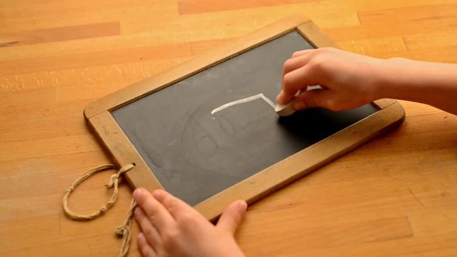 Kid is drawing a geometrical Form on a Chalkboard
