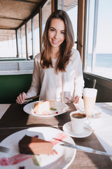 Vertical image of woman on date with coffee and cake