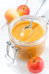 fresh apple sauce in a glass jar, vertical closeup