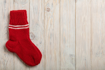 Obraz na płótnie Canvas Knitted wool socks red color on light wooden background.