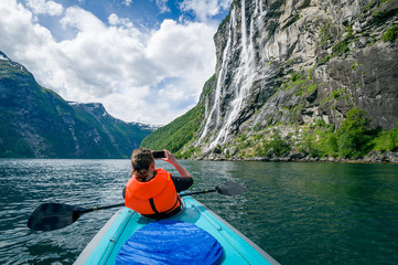 Woman kayaker at Geirngerfjord, Norway.