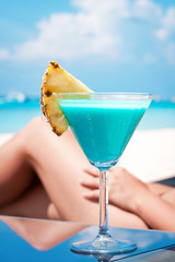 Blue Curacao alcohol cocktail on beach.