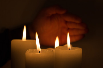 Fototapeta na wymiar burning candles with hand