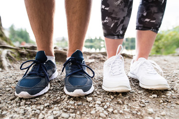 Legs of unrecognizable running couple in sports shoes