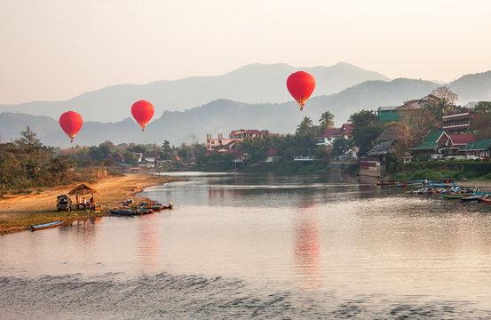 Recreation. Hot air balloons flying over the river Nam Song at sunrise. Vang Vieng, Laos.