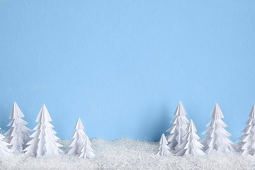 Fototapeta premium Winter Christmas minimalist background with white paper trees on blue .