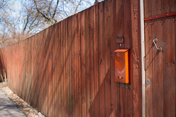 Orange mailbox on orange fence