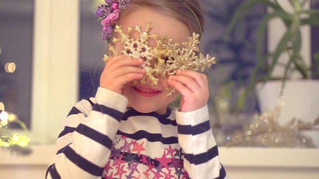 Happy little girl having fun at home, near decorated Christmas tree. Slow motion 240 fps. Full HD 1080p