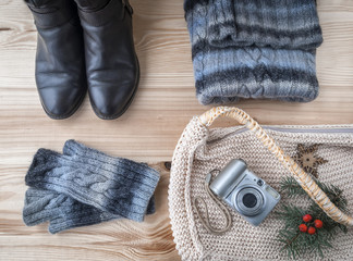Winter casual clothes wool sweater and shoes on wooden background.
