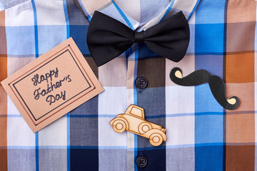 Checkered shirt and greeting card. Props mustache and bow tie. Congratulation with taste.