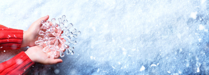 Winter Concept - Young Hands Holding Snowflake
