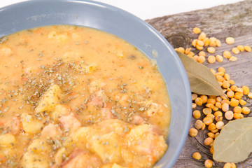 Split pea soup, decorated with some bay leaves, marjoram and peas