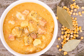 Split pea soup, decorated with some bay leaves, marjoram and peas