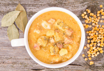 Split pea soup, decorated with some bay leaves, marjoram and peas