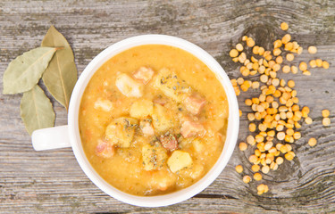 Split pea soup, decorated with some bay leaves, marjoram and peas
