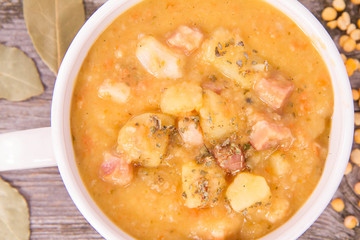 Split pea soup, decorated with some bay leaves, marjoram and peas