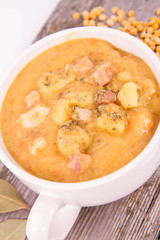 Split pea soup, decorated with some bay leaves, marjoram and peas
