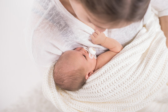 Mutter kuschelt mit Neugeborenem