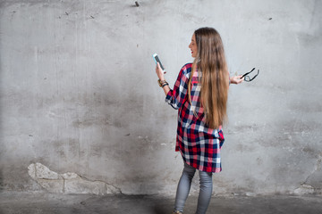 Woman standing back in the old room on the textured gray wall background