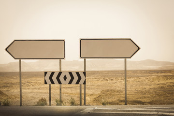 empty road sign arrows on the desert background, selective focus