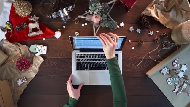 girl writing letter to Santa Claus on laptop at Christmas eve. during Christmas Holiday season. woman  wrapping Christmas gift at her desk and responding to children messages and wishes by email