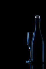 Champagne bottle with glass on black background. Silhouette of a bottle of sparkling wine.