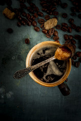 Coffee cup with beans and sugar on vintage metal  background, copy space, top view