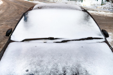 front view on car covered by snow in winter