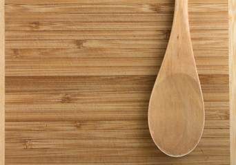 Old scratched cutting board with a wooden spoon