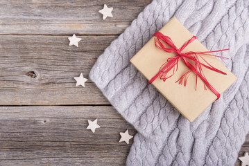Gift box and scarf on wooden boards.