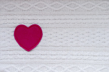 Red heart on white knitted background